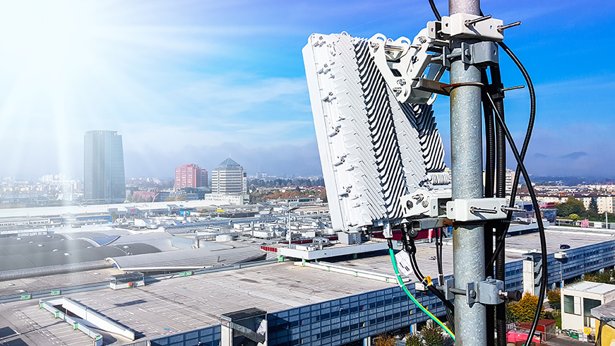 CBRS network antenna on top of an industrial building overlooking the city skyline